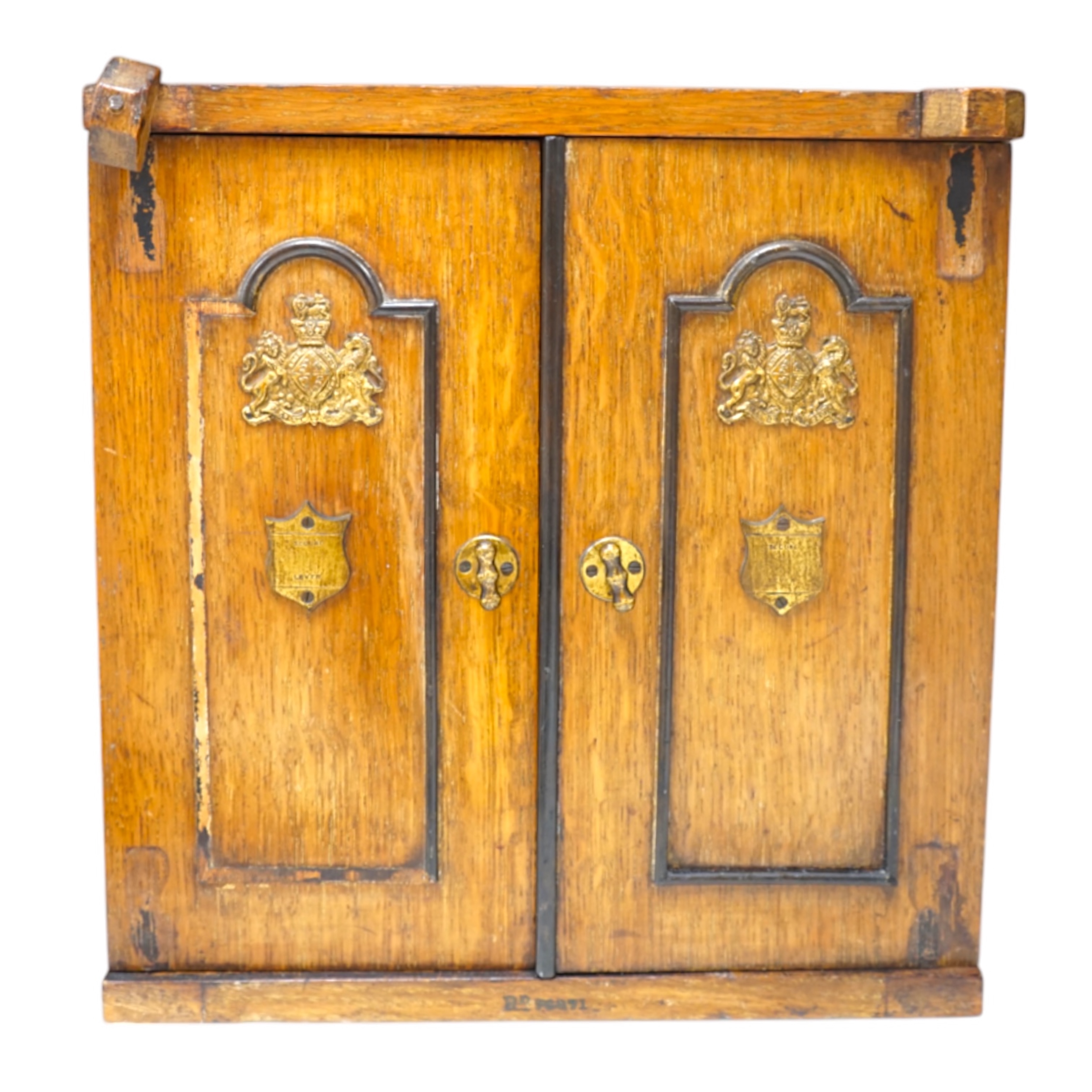 A Victorian oak cigar cabinet modelled as a safe, with brass coat of arms mounts, 30cm wide, 31cm high. Condition - fair